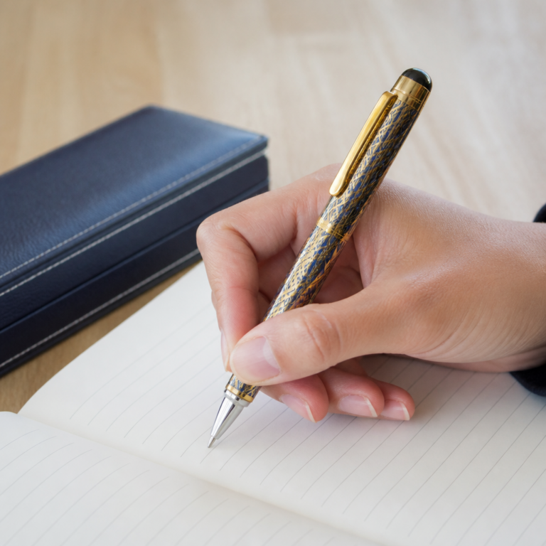 Hand hu00e4lt einen dekorativen Stift beim Schreiben und zeigt die Griffzone