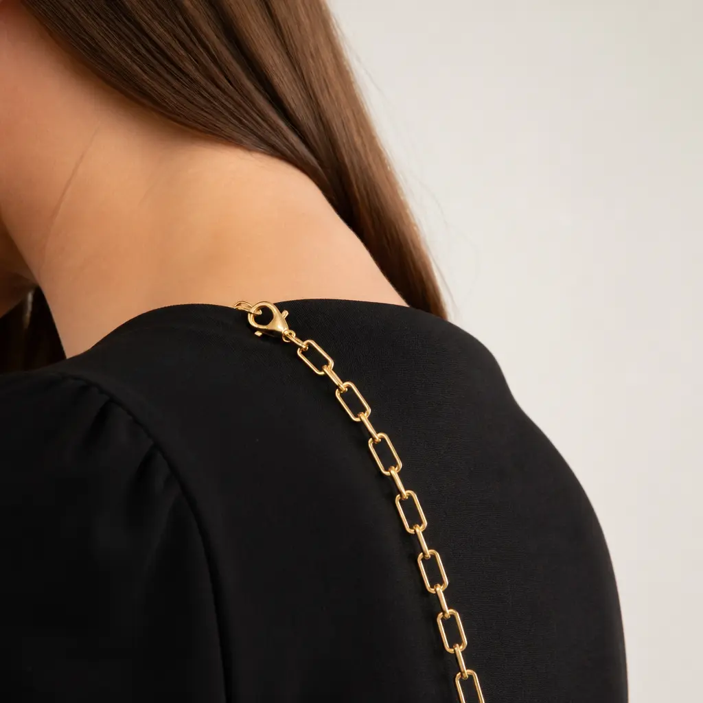 Elegante Schulterkette über einer schlichten schwarzen Schulter drapiert