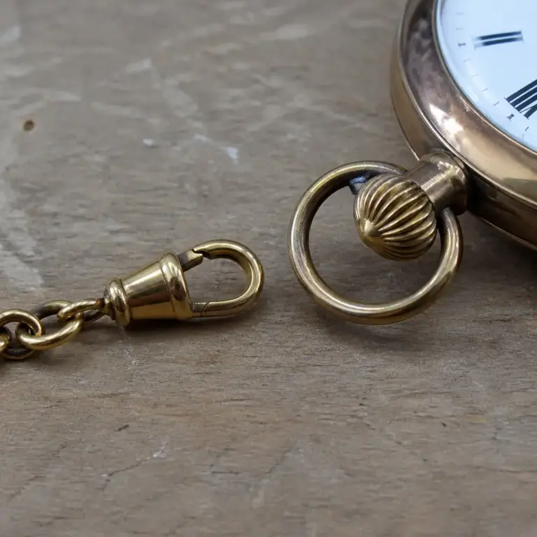 Karabiner einer Uhrenkette neben der Befestigungsu00f6se einer Taschenuhr
